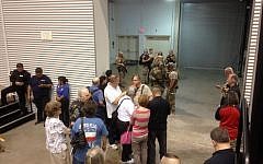 People are sequestered by members of the Garland Police Department inside the Curtis Culwell Center, Sunday, May 3, 2015, in Garland, Texas. A contest for cartoons depictions of the Prophet Muhammad in the Dallas suburb is on lockdown Sunday after authorities reported a shooting outside the building. (photo credit: AP/Nomaan Merchant)