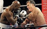Former Republican presidential candidate Mitt Romney, right, throws punches with five-time heavyweight boxing champion Evander Holyfield at a charity fight night event Friday, May 15, 2015, in Salt Lake City (AP Photo/Rick Bowmer)