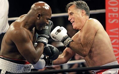 Former Republican presidential candidate Mitt Romney, right, throws punches with five-time heavyweight boxing champion Evander Holyfield at a charity fight night event Friday, May 15, 2015, in Salt Lake City (AP Photo/Rick Bowmer)