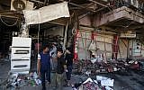 Civilians inspect the site of a bomb attack near restaurants and coffee shops filled with customers in central Baghdad's busy commercial Karradah neighborhood, Iraq, Sunday, May 3, 2015 (AP/Hadi Mizban)