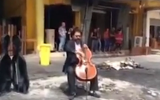 Iraqi cellist Karim Wasfi performing in a Baghdad commercial district on April 28, 2015, hours after a car bomb exploded in the area, killing ten people. (Screen capture: YouTube)