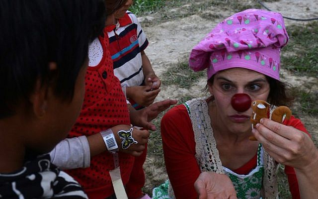 An Israeli medical clown entertains a Nepalese earthquake victim during a visit to a makeshift army camp in Kathmandu on May 6, 2015 (photo credit: AFP/PRAKASH MATHEMA) An Israeli medical clown entertains a Nepalese earthquake victim during a visit to a makeshift army camp in Kathmandu on May 6, 2015 (photo credit: AFP/PRAKASH MATHEMA)
