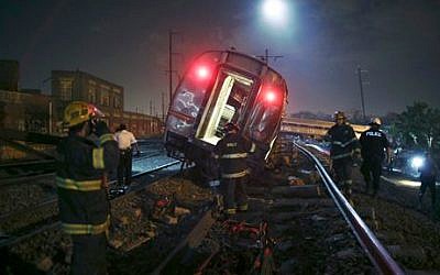 Emergency personnel work the scene of a deadly train wreck, Tuesday, May 12, 2015, in Philadelphia. (photo credit: AP/Joseph Kaczmarek)