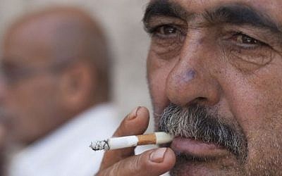 A Palestinian man smokes a cigarette in the alleys of Jerusalem's Old City, on June 12, 2013. (Neal Badache/Flash90)