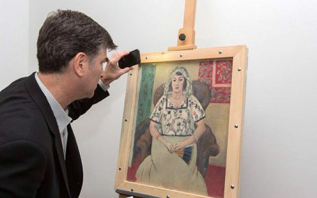 This handout photo released by Art Recovery International shows Christopher Marinello, lawyer representing the heirs of Paul Rosenberg, looking at Henri Matisse’s ‘Femme Assise’ ('Seated Woman') painting on May 15, 2015 in Munich, Germany (AFP PHOTO / ART RECOVERY / WOLF HEIDER-SAWALL) This handout photo released by Art Recovery International shows Christopher Marinello, lawyer representing the heirs of Paul Rosenberg, looking at Henri Matisse’s ‘Femme Assise’ ('Seated Woman') painting on May 15, 2015 in Munich, Germany (AFP PHOTO / ART RECOVERY / WOLF HEIDER-SAWALL)