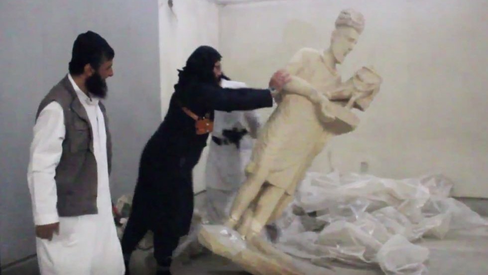 In this image made from video posted on a social media account affiliated with the Islamic State group on Thursday, Feb. 26, 2015, a militant topples an ancient artifact in the Ninevah Museum in Mosul, Iraq. (Photo credit: AP via militant social media account, File) Illustrative: In this image made from video posted on a social media account affiliated with the Islamic State group on Thursday, February 26, 2015, a militant topples an ancient artifact in the Ninevah Museum in Mosul, Iraq. (Photo credit: AP via militant social media account, File)