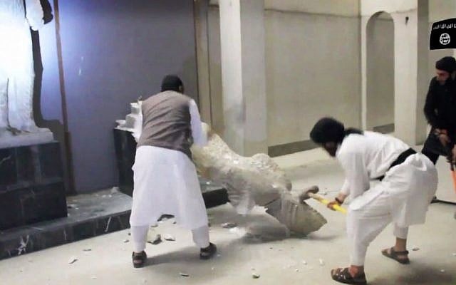 In this image made from video posted on a social media account affiliated with the Islamic State group on Thursday, Feb. 26, 2015, militants take sledgehammers to an ancient artifact in the Ninevah Museum in Mosul, Iraq. (Photo credit: AP via militant social media account, File)