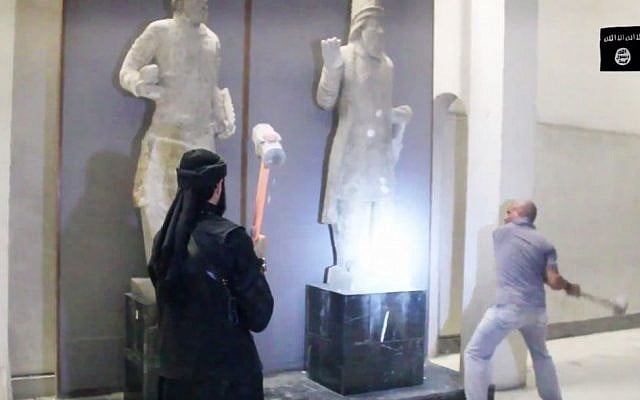In this image made from video posted on a social media account affiliated with the Islamic State group on Thursday, Feb. 26, 2015, militants attack ancient artifacts with sledgehammers in the Ninevah Museum in Mosul, Iraq. (Photo credit: AP via militant social media account, File)