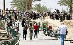 Residents from the city of Ramadi, who fled their homes on May 16, 2015 as Islamic State (IS) group militants tightened their siege on the last government positions in the capital of Anbar province, a day after they seized the city's government headquarters, wait to cross Bzeibez bridge, on the southwestern frontier of Baghdad with Anbar province, after IS group jihadists took control of all the other routes connecting the province with the Iraqi capital. Taking control of Ramadi would constitute the group's most important victory this year in Iraq, and would give the jihadists control of the capitals of two of its largest provinces. AFP PHOTO/SABAH ARAR
