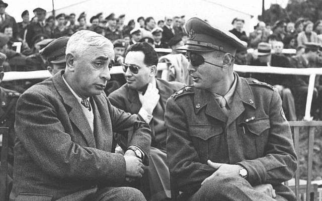 Defense Minister Pinchas Lavon, left, and IDF Chief of the General Staff Moshe Dayan, with Shimon Peres in the background, on February 8, 1953 (photo credit: GPO/ courtesy of IDF Archive in the Defense Ministry)
