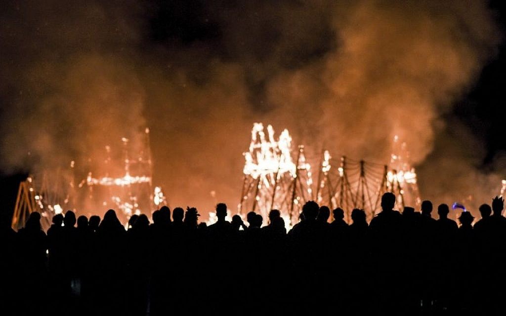 Revelers watch the wood installations burn at the second annual Midburn festival, the Israeli version of Burning Man, on May 24, 2015. (Ben Kelmer/Flash90) Revelers watch the wood installations burn at the second annual Midburn festival, the Israeli version of Burning Man, on May 24, 2015. (Ben Kelmer/Flash90)