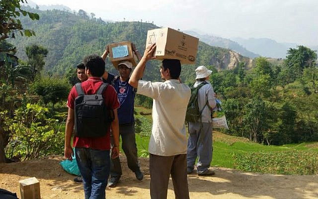 Nepalese aid workers carrying supplies they received from Israel (photo credit: Tevel b’Tzedek)