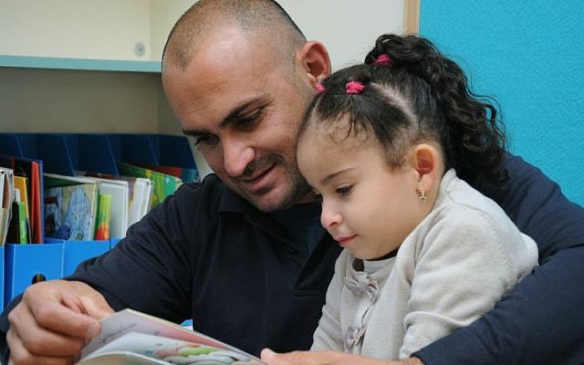 Father reads to his daughter in Baqa al-Gharbiyye. (photo credit: Akmal Nagnagy)