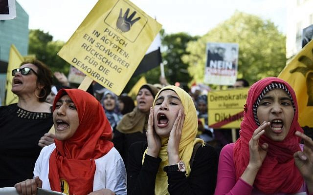 Young women wearing headscarves hold up a poster reading "Coup in Egypt - Severe Setback for Democracy" as they take part in a demonstration against the policy of the Egyptian President on June 3, 2015 near the Egyptian Embassy in Berlin. (AFP PHOTO / ODD ANDERSEN) Young women wearing headscarves hold up a poster reading "Coup in Egypt - Severe Setback for Democracy" as they take part in a demonstration against the policy of the Egyptian President on June 3, 2015 near the Egyptian Embassy in Berlin. (AFP PHOTO / ODD ANDERSEN)