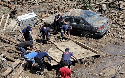 Rescuers and local residents collect debris at a flooded area in the Georgian capital Tbilisi on June 15, 2015. (Vano Shlamov/AFP)