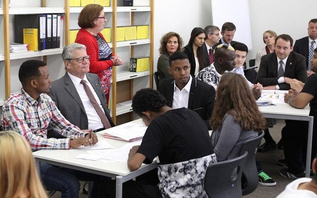 Iluustrative photo: German President Joachim Gauck (C) meets young refugees during his visit at the Friedrich-Feld vocational school of commerce in Giessen, central Germany, on June 17, 2015. (Daniel Roland/AFP)