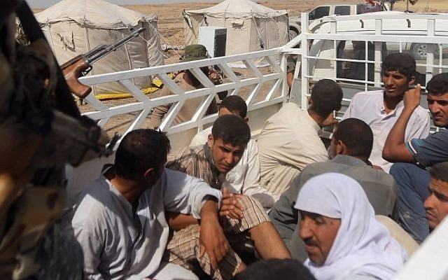 Iraqi Shiite fighters from the popular mobilization units arrest men suspected of belonging to the Islamic State jihadist group in al-Nibaie area, north-west of Baghdad, on May 27, 2015, (AFP/AHMAD AL-RUBAYE)