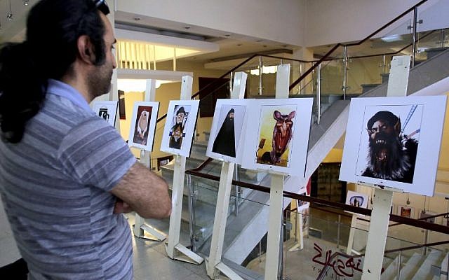 An Iranian man looks at cartoons displayed during an exhibition as part of the Daesh (Islamic State jihadist group) International Cartoon and Caricature Contest on May 31, 2015 at the Arasbaran gallery in Tehran. (AFP PHOTO / ATTA KENARE) An Iranian man looks at cartoons displayed during an exhibition as part of the Daesh (Islamic State jihadist group) International Cartoon and Caricature Contest on May 31, 2015 at the Arasbaran gallery in Tehran. (AFP PHOTO / ATTA KENARE)