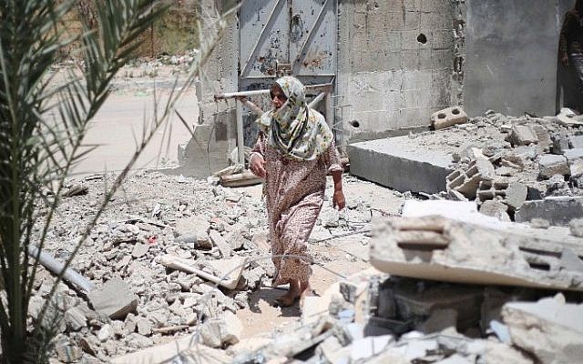 A Palestinian woman walks amid the rubble of buildings which were destroyed during the 50-day war between Israel and Hamas in the summer of 2014, in the village of Khuzaa, east of Khan Yunis, in the southern Gaza Strip, June 1, 2015. (AFP/SAID KHATIB) A Palestinian woman walks amid the rubble of buildings which were destroyed during the 50-day war between Israel and Hamas in the summer of 2014, in the village of Khuzaa, east of Khan Yunis, in the southern Gaza Strip, June 1, 2015. (AFP/SAID KHATIB)