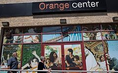 Israelis walk past a store of Israeli telecom operator Partner, which has a licence from French company Orange to use its brand, in Jerusalem on June 4, 2015. (AFP PHOTO / MENAHEM KAHANA)