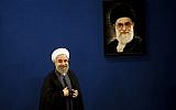 Iranian President Hassan Rouhani stands next to a portrait of supreme leader Ayatollah Ali Khamenei as he leaves at the end of a press conference in Tehran on June 13, 2015. (AFP Photo/Behrouz Mehri)