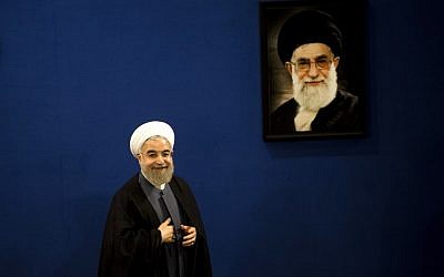 Iranian President Hassan Rouhani stands next to a portrait of supreme leader Ayatollah Ali Khamenei as he leaves at the end of a press conference in Tehran on June 13, 2015. (AFP Photo/Behrouz Mehri)
