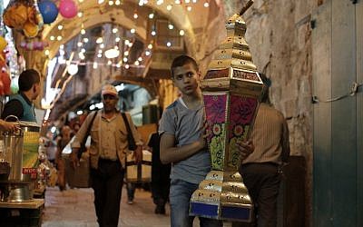 Illustrative. A Palestinian boy carries a lantern past shops in the Old City of Jerusalem on June 16, 2015.(AFP PHOTO/AHMAD GHARABLI)