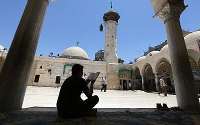 A Palestinian man reads a copy of the Koran, Islam's holy book, in a mosque on the first day of the holy fasting month of Ramadan in Gaza City, on June 18, 2015. (AFP PHOTO/MAHMUD HAMS)