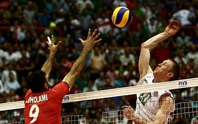 US player David Smith (R) smashes past Iran's Adel Gholami (L) during the volleyball World League pool B match between Iran and USA at Tehran's Azadi arena on June 19, 2015, in which Iran won 3-0 (Behrouz Mehri/AF)