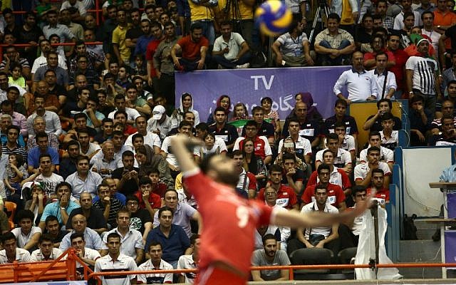 Iran's Adel Gholami serves the ball as a few women sit amid the fans during the volleyball World League pool B match between Iran and USA at Tehran's Azadi arena on June 19, 2015, in which Iran won 3-0 (AFP PHOTO / BEHROUZ MEHRI) Iran's Adel Gholami serves the ball as a few women sit amid the fans during the volleyball World League pool B match between Iran and USA at Tehran's Azadi arena on June 19, 2015, in which Iran won 3-0 (AFP PHOTO / BEHROUZ MEHRI)