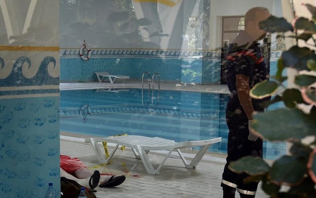 A Tunisian medic stands next to the body of a tourist at the Imperial hotel in the resort town of Sousse, a popular tourist destination 140 kilometers (90 miles) south of the Tunisian capital, on June 26, 2015. At least 27 people, including foreigners, were killed in a mass shooting at a Tunisian beach resort packed with holidaymakers, in the North African country's worst attack in recent history. (AFP PHOTO / FETHI BELAID)
