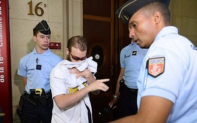 A member of the Islamist group Forsane Alizza (center), accused of preparing Islamist attacks in France, arrives for the opening day of his trial in Paris, June 8, 2015. (AFP/Bertrand Guay)