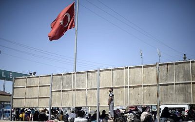 Syrian refugees gather on the side of the road that leads to the Akcakale border gate as they wait to return to their home in the northern Syrian town of Tel Abyad,  June 18, 2015. AFP PHOTO/BULENT KILIC