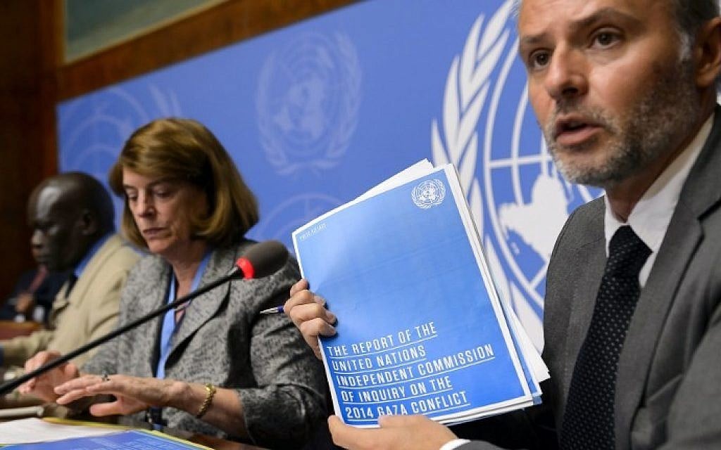 Information Officer for the Office of the High Commissioner for Human Rights Rolando Gomez holds the report of the Commission of Inquiry on the 2014 Gaza conflict next to Commission chairperson Mary McGowan Davis, center, and Commission member Doudou Diene during a press conference on their report on June 22, 2015 at the United Nations Office in Geneva. (AFP / FABRICE COFFRINI)
