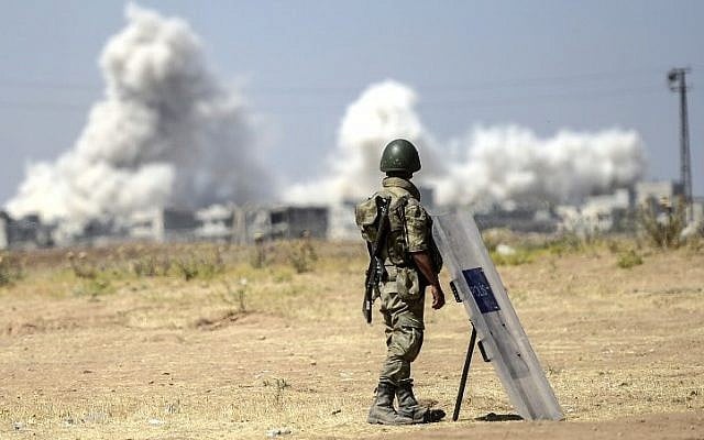 A picture taken from the Turkish side of the border with Syria shows a Turkish soldier watching as smoke rises from the Syrian town of Kobani, on June 27, 2015. (Bulent Kilic/AFP) A picture taken from the Turkish side of the border with Syria shows a Turkish soldier watching as smoke rises from the Syrian town of Kobani, on June 27, 2015. (Bulent Kilic/AFP)