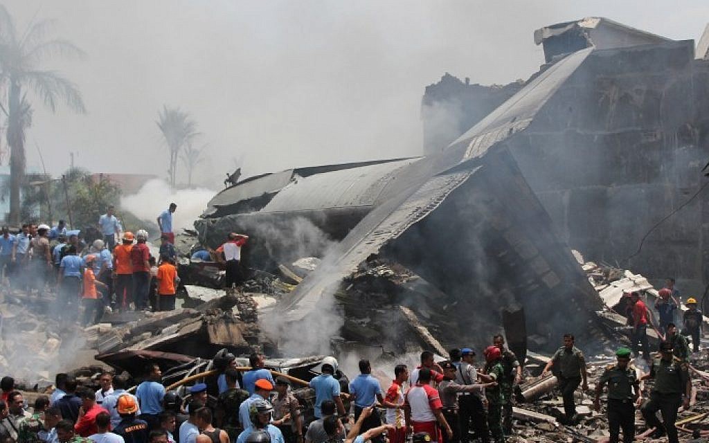 Indonesian rescue personnel work at the scene of an Indonesian military C-130 Hercules aircraft crash in Medan on June 30, 2015. The transport plane crashed shortly after take-off in a city on Sumatra island, exploding in a ball of flames in a residential area. (AFP/ATAR)
