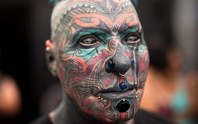 A man whose face is completely covered with tattoos poses during the three-day annual tattoo festival on June 6, 2015 in the coastal city of Tel Aviv (Menahem Kahana/AFP) A man whose face is completely covered with tattoos poses during the three-day annual tattoo festival on June 6, 2015 in the coastal city of Tel Aviv (Menahem Kahana/AFP)