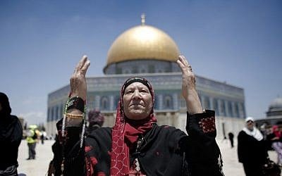Palestinian Muslim worshipers pray outside the Dome of the Rock at the Al-Aqsa Mosque compound in Jerusalem during the first Friday prayer of the holy month of Ramadan, on June 19, 2015. (AFP/AHMAD GHARABLI)