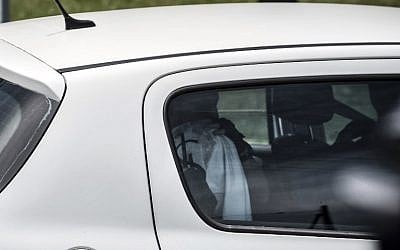 A suspect (head covered) in the attack on the Air Products gas factory is taken away in a car of the French criminal investigation police after a search at the suspect's home in the Moines neighborhood of Saint-Quentin-Fallavier, near Lyon, central eastern France, on June 26, 2015. (AFP/JEAN-PHILIPPE KSIAZEK)