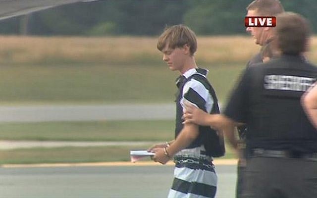 In this screen grab taken from WBTV News, shooting suspect Dylann Roof (L) is escorted by police at the Shelby-Cleveland County Regional Airport for extradition back to Charleston, South Carolina in Shelby, North Carolina on June 18, 2015. (AFP/ WBTV NEWS/ HO) In this screen grab taken from WBTV News, shooting suspect Dylann Roof (L) is escorted by police at the Shelby-Cleveland County Regional Airport for extradition back to Charleston, South Carolina in Shelby, North Carolina on June 18, 2015. (AFP/ WBTV NEWS/ HO)