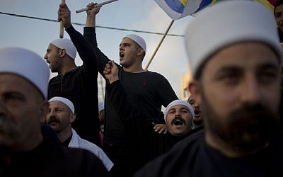 Members of Israel's Druze minority shout slogans and wave their flags during a march in the Druze village of Yarka, Israel, Sunday, June 14, 2015 (AP/Ariel Schalit)