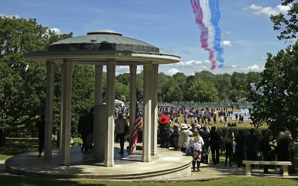 People gather at the riverside meadow west of London as the Red Arrows RAF display team fly over the Magna Carta memorial in Runnymede, England, during a commemoration ceremony Monday June 15, 2015, to celebrate the 800th anniversary of the groundbreaking accord called Magna Carta. (Steve Parsons / Pool photo via AP)