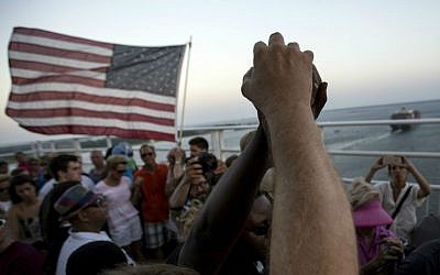 People raise their hands as a show of unity as thousands of marchers meet in the middle of Charleston's main bridge after nine black church parishioners were gunned down during a Bible study, Sunday, June 21, 2015, in Charleston, S.C. (AP Photo/Stephen B. Morton)