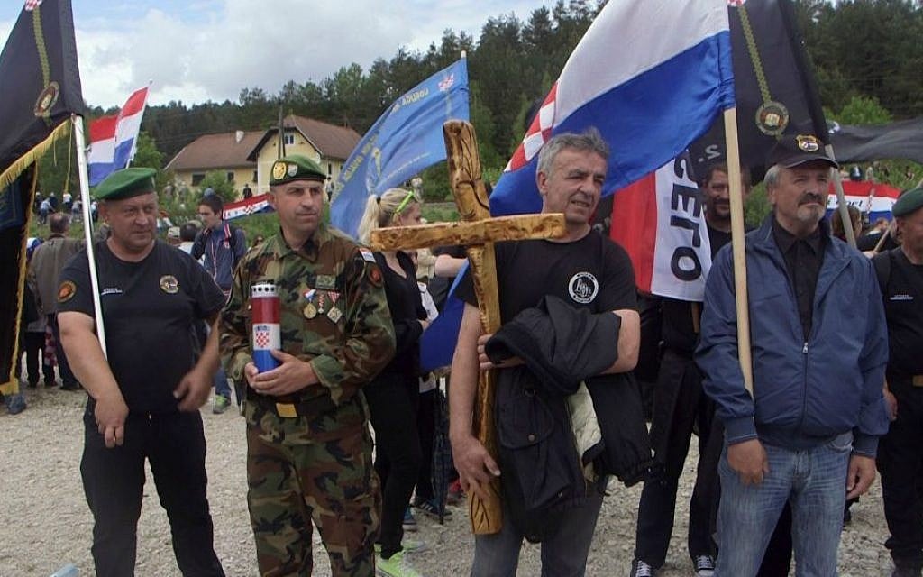 In this May 16, 2015 photo, men from Croatia attend a memorial to the thousands of victims of the mass killings by Yugoslav communists, in Bleiburg, Austria. (AP Photo/Darko Bandic)