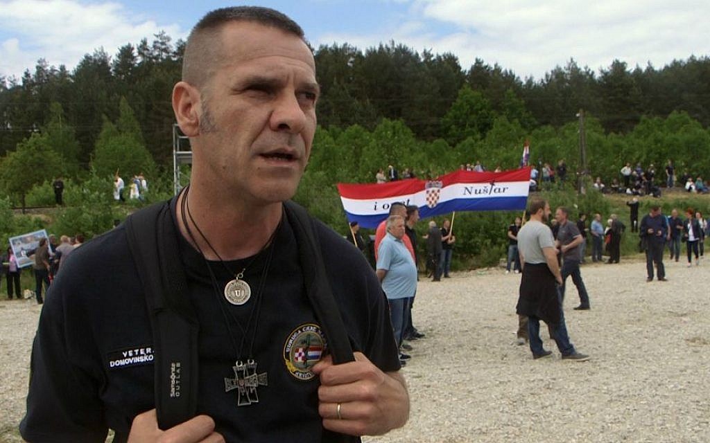 In this May 16, 2015 photo, Ivica Safaric from Croatia attends a memorial to the thousands of victims of the mass killings by Yugoslav communists, in Bleiburg, Austria. (AP Photo/Darko Bandic)