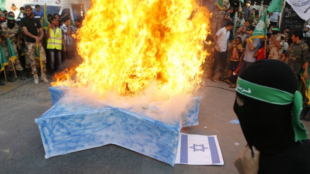 Masked Hamas members burn a cut-out of a Star of David during a demonstration in Rafah in the southern Gaza Strip, August 17, 2014. (Photo by Abed Rahim Khatib/Flash90) Masked Hamas members burn a cut-out of a Star of David during a demonstration in Rafah in the southern Gaza Strip, August 17, 2014. (Photo by Abed Rahim Khatib/Flash90)