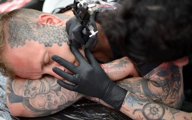 A man gets his face tattooed during the third annual tattoo festival at Haoman Club in Tel-Aviv on June 6, 2015 (Tomer Neuberg/Flash90)