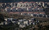 Construction in the ultra-Orthodox settlement of Beitar Illit, with the Arab village of Wadi Fukin in the foreground, on June 17, 2015. (Nati Shohat/Flash90)