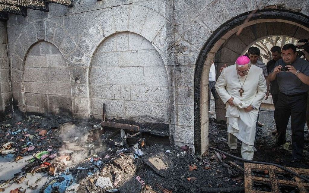 A priest inspects the damage caused to the Church of the Multiplication at Tabgha, on the Sea of Galilee, in northern Israel, which was set on fire in what police suspect was an arson attack, June 18, 2015. (Basel Awidat/Flash90)