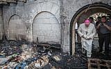A priest inspects the damage caused to the Church of the Multiplication at Tabgha, on the Sea of Galilee, in northern Israel, which was set on fire in what police suspect was an arson attack, June 18, 2015. (Basel Awidat/Flash90)